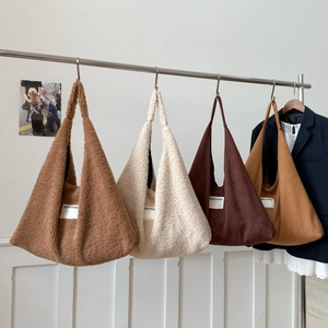 Detail view of assorted lamb wool and corduroy tote bags in warm autumn earthy tones