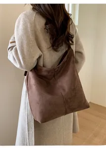 Detail of brown suede hobo bag showing fine matte texture and vertical stitching seam