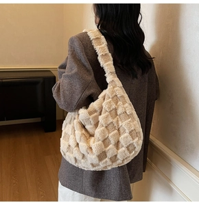 Detail of plush checkered shoulder bag styled with a stylish brown winter wool coat