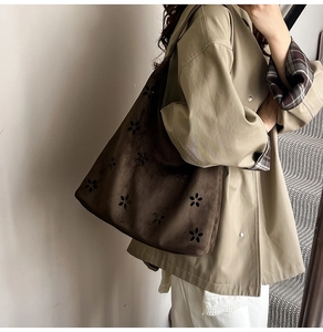 Side view of dark brown suede tote bag with laser-cut floral patterns and boho style