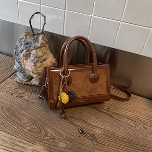 Nahaufnahme der braunen Vintage-Umhängetasche mit Wildleder-Patchwork und Anhänger