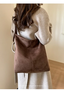 Detail view of large dark brown suede hobo bag with vintage stitching and texture