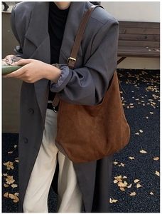 Brown suede hobo bag with leather strap shown in an autumn street style setting