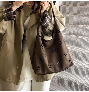 Close-up of vintage dark brown suede tote bag featuring intricate floral cut-out details