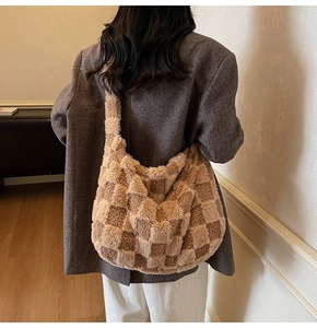 Detailed view of plush checkered hobo bag worn by model in a cozy indoor setting