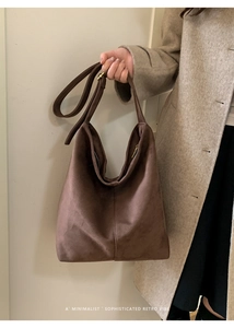 Close-up of dark brown suede hobo bag with adjustable gold buckle and retro vibe