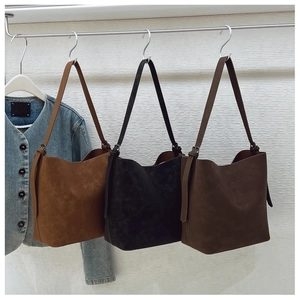 Detail of three retro leather bucket bags in brown and black with adjustable straps