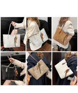 Detail view of large retro tote bag featuring a tassel charm and spacious interior design