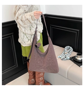 Detailed view of a purple large capacity hobo bag worn with an elegant autumn outfit