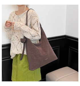 Dark brown large capacity tote bag shown with adjustable shoulder strap and small pouch