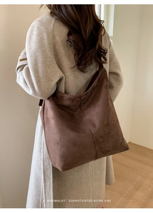 Detailed back view of a retro brown suede hobo bag showing minimalist drape and wide strap
