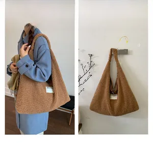 Detailed view of brown plush tote bag with white woven label on fuzzy fleece fabric
