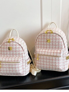 Pink and white tweed backpack with gold logo plaque and studs for stylish commuting