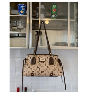 Close-up of beige tote bag featuring heart patterns and BAI MIAO ER 1996 leather patch