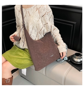 Brown suede tote bag detail featuring the white logo and attached small matching pouch