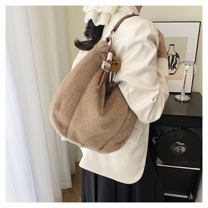 Détail du sac hobo en peluche beige avec bandoulière en cuir et breloque ours léopard