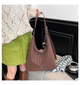 Close-up of brown leopard print tote bag with adjustable strap and brand logo
