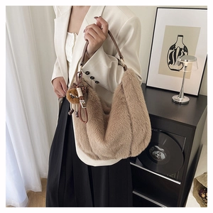 Détail du sac à épaule en fausse fourrure marron clair avec accessoire pendentif ours