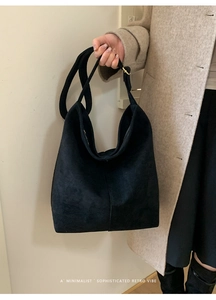 Close-up of a minimalist black suede hobo bag with retro texture and zipper closure