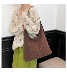 Detail of large brown leopard print tote bag with soft suede texture and embossed patterns