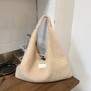 Close-up of fluffy lamb wool tote bag showing square SEEYOU patch and toggle closure