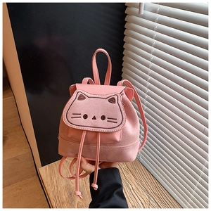 Vue détaillée du sac à dos rose à cordon avec broderie chat et texture en daim doux