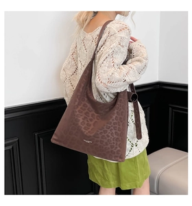 Detail view of the brown leopard print hobo bag showing texture and logo print