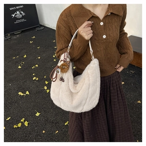 Sac croissant en fausse fourrure beige avec pendentif peluche dans un décor d'automne
