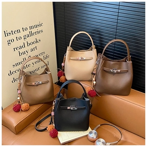Detailed view of four stylish bucket bags in cream, brown, coffee, and black leather