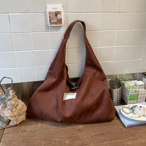 Detailed view of brown suede tote bag with toggle button and SEE YOU fabric label