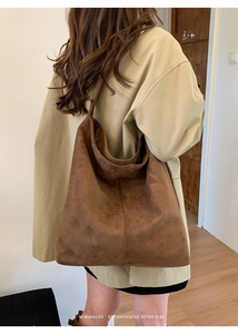 Detail of a large retro velvet tote bag in dark brown worn over the shoulder
