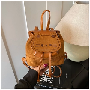 Détail de la broderie chat et du cordon sur un mini sac à dos marron en faux daim