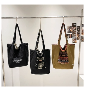 Detail of contrast ethnic pattern plush pockets and brand labels on large tote bags