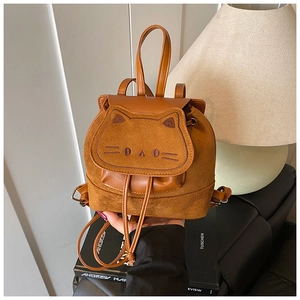 Détail d'un mini sac à dos en daim marron avec visage de chat brodé et oreilles mignonnes