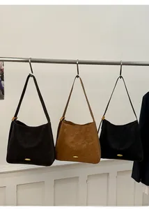 Frosted matte leather tote bags in brown and black colors hanging on a metal rack