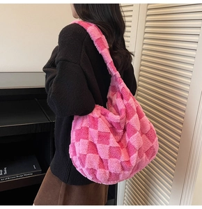 Detail of plush checkered shoulder bag showing soft texture and large capacity on model