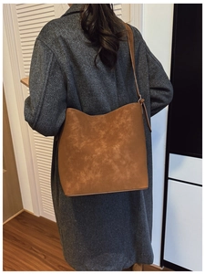 Retro brown faux leather bucket bag showing textured finish and large capacity scale