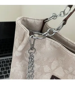 Detail of floral jacquard tote bag with silver chain and brown leather strap