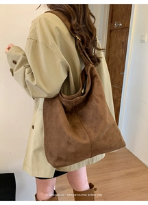 Close-up of a large brown vintage suede tote bag showing texture and retro metal zipper