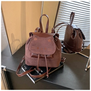 Détail d'un sac à dos marron avec broderie chat et fermeture par cordon