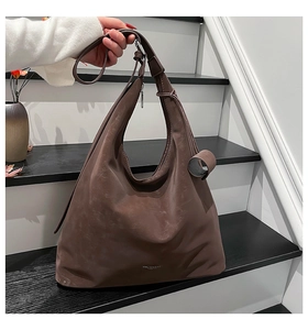 Detail of soft brown textured hobo bag with MALIVIA DAO logo and adjustable strap