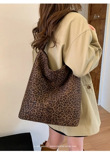 Detailed close-up of leopard print tote bag paired with classic khaki trench coat