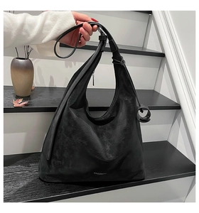 Detailed view of black hobo bag texture with silver logo and adjustable strap
