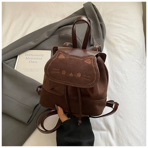 Détail d'un mini sac à dos marron foncé avec rabat en forme de chat et broderie