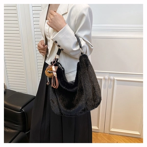 Détail d'un sac hobo en fausse fourrure noire avec bandoulière et breloque léopard