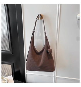 Detail of dark coffee brown hobo bag with adjustable strap and matte leather finish