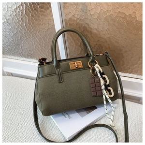 Détail du sac à main vert olive en toile avec fermoir rotatif doré et bijou de sac