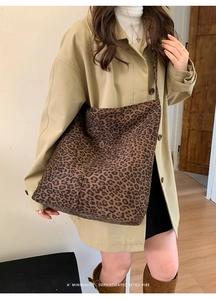 Detailed close-up of leopard print suede bucket bag with long shoulder strap