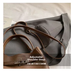 Dettaglio borsa a secchiello in pelle marrone con chiusura argento e tracolla regolabile