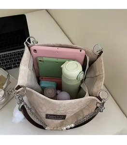 Top view of spacious interior storage in beige tote bag with chic pearl chain detail